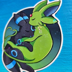 Op de afbeelding: Een zwarte en groene cartoonillustratie van twee Pok&eacute;mon-personages, een Glacenoir en een Nachtkaatje, die tegen elkaar aan knuffelen op een donkere achtergrond met glinsterende sterren.