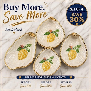 May include: Four decorative oyster shell dishes with a gold rim and a lemon design. The shells are white with a gold edge and feature a painted yellow lemon with green leaves and a pink flower. The text "Buy More, Save More" is at the top.