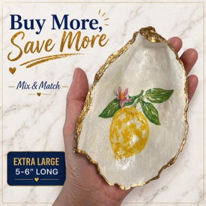 May include: Extra large oyster shell trinket dish, hand-painted with a yellow lemon and pink flower design. The shell has a gold-painted edge and measures 5-6 inches long. Text on the image reads "Buy More, Save More" and "Mix & Match".