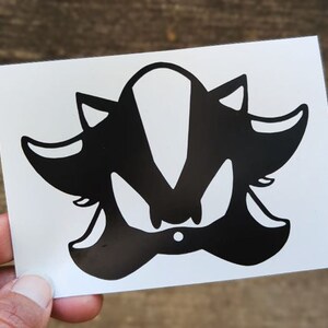 May include: Black and white silhouette of Shadow the Hedgehog, a video game character, on a white background.