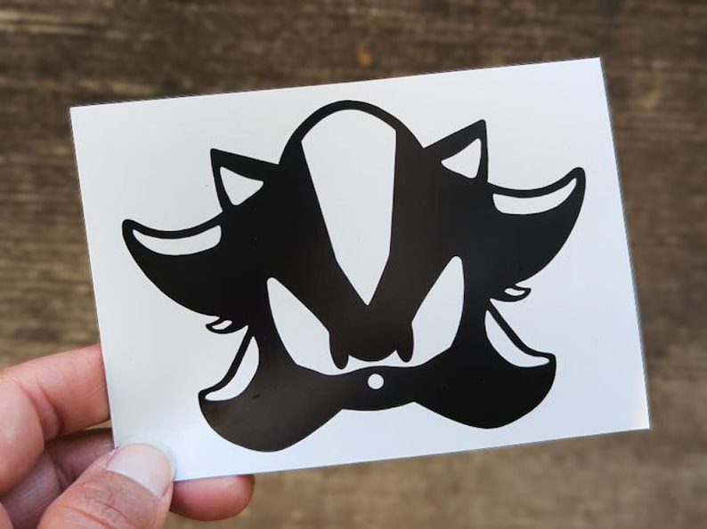 May include: Black and white silhouette of Shadow the Hedgehog, a video game character, on a white background.
