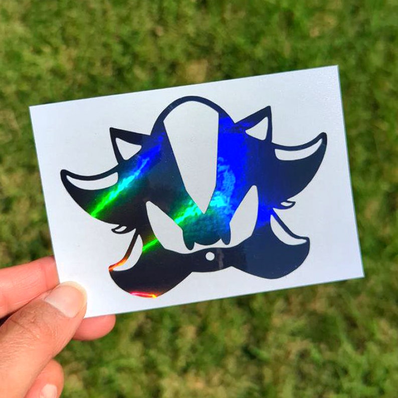 May include: A black and white iridescent vinyl sticker of Shadow the Hedgehog from the Sonic the Hedgehog video game series.