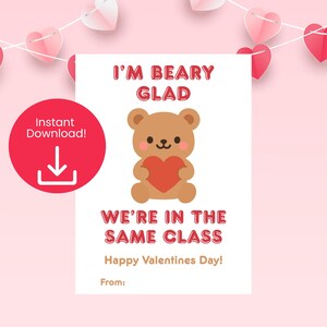 Puede incluir: Tarjeta de San Valentín con un oso de dibujos animados sosteniendo un corazón rojo. La tarjeta dice: "I'M BEARY GLAD WE'RE IN THE SAME CLASS Happy Valentines Day!" Un círculo rojo con un icono de descarga está en la esquina superior izquierda.