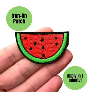 May include: A watermelon-shaped iron-on patch with a red interior, black seeds, and a green rind. The patch is embroidered with black thread and has the text "Iron-On Patch" and "Apply in 1 minute!" on green circles.