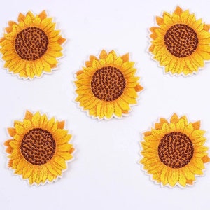 May include: Five embroidered sunflower patches. Each patch features a detailed design with yellow petals, a brown center, and a white border. The patches are arranged on a white background.