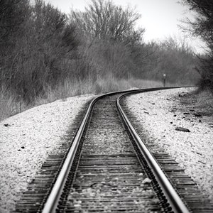 Black and white photographic print of rugged railroad tracks