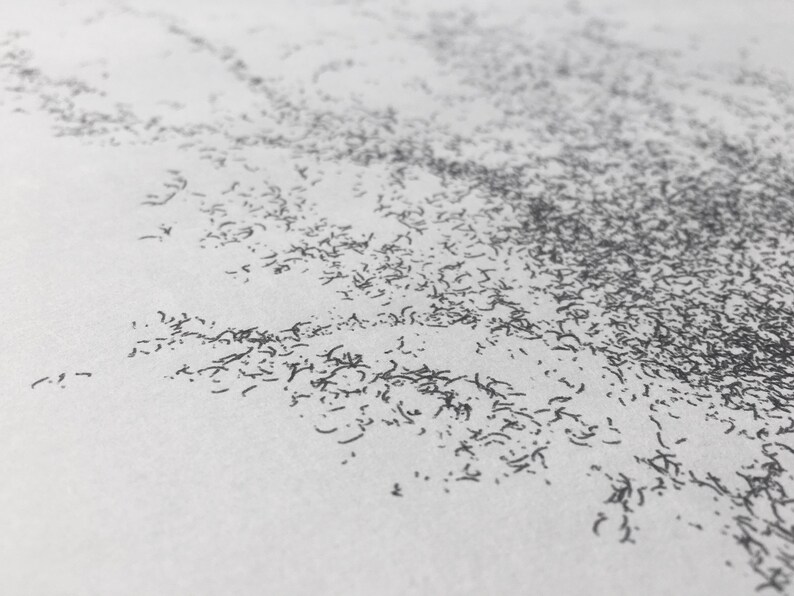 May include: A close-up of a white surface with a scattered pattern of small, dark gray lines.