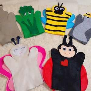 May include: A collection of six colorful felt hand puppets in the shapes of various insects and creatures. The puppets include a snail, broccoli, bee, bird, butterfly, and ladybug. Each puppet has a unique design and facial expression.