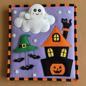 Könnte beinhalten: Ein Halloween-Filzbrett mit lila Hintergrund. Es zeigt einen weißen Geist in einer Wolke, einen grünen Hexenhut mit Fledermäusen, ein schwarzes Haus mit orangefarbenem Dach, einen Kürbis, eine schwarze Katze und weiße Sterne. Der Rand ist schwarz und orange.