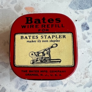 May include: A red metal tin with the text "Bates WIRE REFILL FOR BATES STAPLER makes its own staples." The tin features a yellow rectangle with a black illustration of a stapler. The text "THE BATES MFG. COMPANY ORANGE, N. J., U. S. A." is also visible.