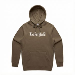 May include: A brown hooded sweatshirt with the word "Bakersfield" printed in white across the chest. The sweatshirt has a front pocket and a drawstring at the hood.