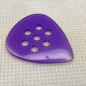 May include: Purple guitar pick with seven round holes.