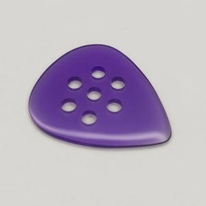 Peut inclure: Un médiator de guitare violet translucide avec sept trous circulaires. Le médiator a une forme de goutte d'eau avec un sommet arrondi et un fond pointu. Le médiator est posé sur un fond blanc.
