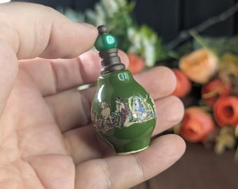 Frasco de perfume miniatura antiguo de porcelana verde con decoración de escena griega clásica.