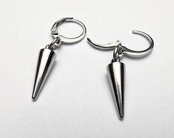 May include: A pair of silver earrings with a pointed cone design. The earrings are made of metal and have a simple, modern style.