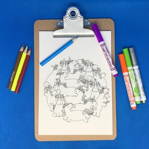 May include: A white sheet of paper with a black and white illustration of a group of unicorns. The paper is on a clipboard with a blue pencil and a purple, orange, and green marker.