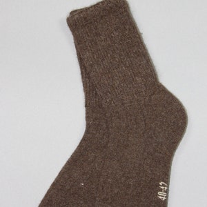 Peut inclure: Une paire de chaussettes en laine marron avec une étiquette blanche indiquant "40/42".