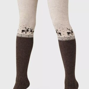 May include: Two-tone over-the-knee socks. The upper section is light beige, changing to dark brown below the knee. A decorative band featuring a reindeer pattern is at the transition. The socks have a ribbed design.