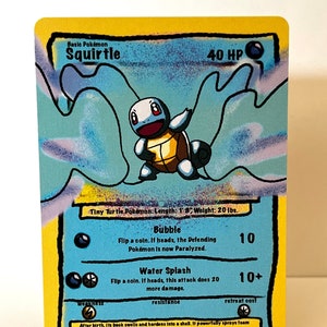 May include: A blue and yellow Squirtle Pokemon card featuring a cartoon image of Squirtle. The card has the text "Basic Pokemon Squirtle 40 HP" at the top. The card also has the text "Tiny Turtle Pokemon: Length: 1'8" Weight: 20 lbs." at the bottom. The card has three attacks: Bubble, Water Splash, and Retreat Cost.
