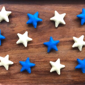 May include: A wooden tray with twelve felt stars, six blue and six white.