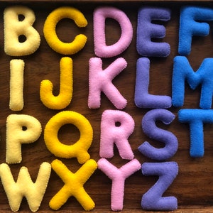 Wielkie litery alfabetu filcowego w ciepłych kolorach