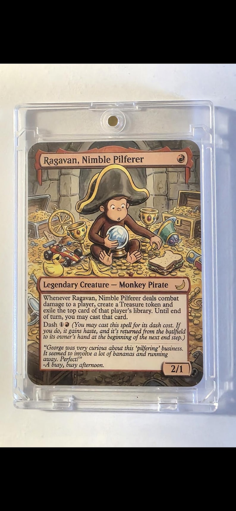 Op de afbeelding: Een Magic: The Gathering-kaart met Ragavan, Nimble Pilferer, een aap-piraat. De kaart toont een aap met een piratenhoed, omringd door schatten. De kaart zit in een beschermende hoes.