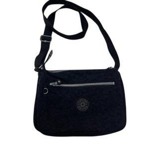 May include: Black crossbody bag with a long adjustable strap. The bag features a zippered front pocket and a circular logo emblem. The bag is made of a durable, textured material.
