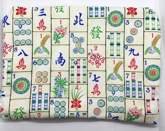 May include: A white fabric with a repeating pattern of mahjong tiles. The tiles are in various colours, including red, green, blue, and black. The tiles feature Chinese characters and numbers. The fabric is ideal for crafting projects, such as making bags, pouches, or quilts.