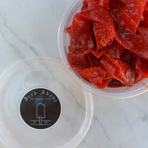 Gourmet Sweet sour and Savory strawberry Candy Belts coated in Homemade chamoy and spice seasoning