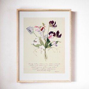 May include: A framed floral print featuring a watercolor illustration of a bouquet of sweet pea flowers in shades of purple, pink, and white. The print includes a quote from Philippians 4:8 in a handwritten style font. The frame is made of light-colored wood.