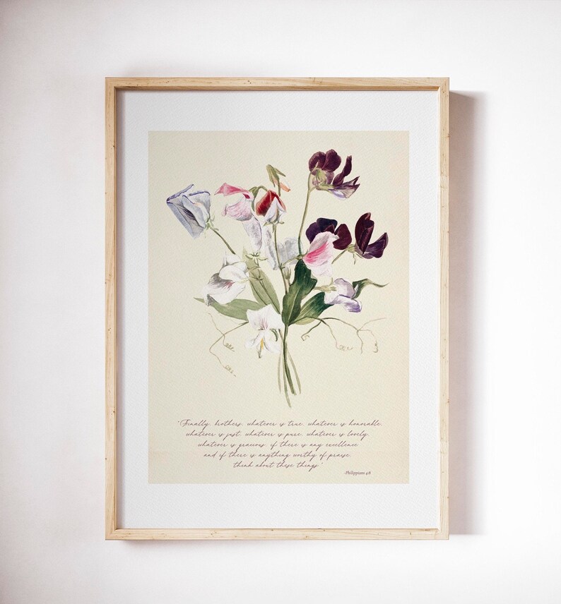 May include: A framed floral print featuring a watercolor illustration of a bouquet of sweet pea flowers in shades of purple, pink, and white. The print includes a quote from Philippians 4:8 in a handwritten style font. The frame is made of light-colored wood.