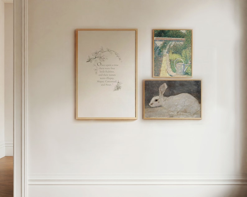 May include: Three framed prints on a white wall. The leftmost print features a black and white illustration of a tree with text that reads "Once upon a time there were four little rabbits, and their names were Flopsy, Mopsy, Cottontail and Peter.". The middle print is a white rabbit lying down on a dark background. The rightmost print is a painting of a garden with a watering can.