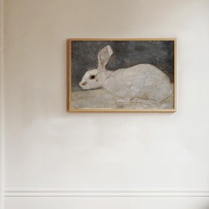This vintage painting of a white rabbit is horizontal. The white rabbit is against a dark gray background with an off white ground. We see him in profile with his ears high.