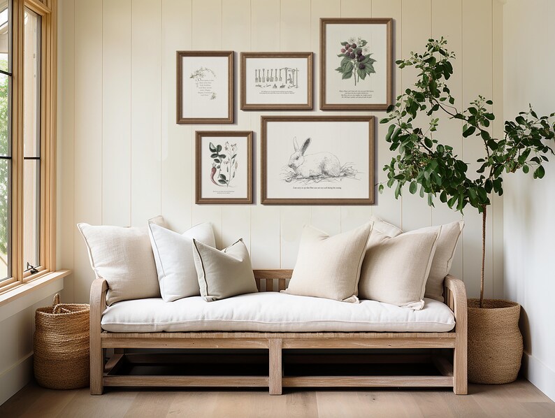 K&ouml;nnte beinhalten: Ein wei&szlig;es Leinen-Sofa mit drei Kissen steht vor einer wei&szlig;en Wand mit f&uuml;nf gerahmten botanischen Drucken. Eine Topfpflanze steht in der Ecke des Raumes.