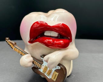 Figura de diente musical hecha a mano tocando la guitarra