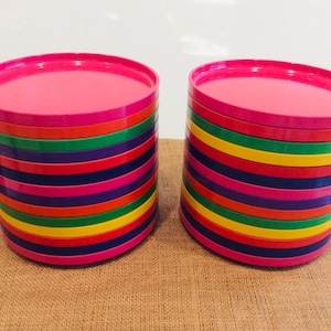 May include: Two stacks of colorful plastic plates. Each stack has 10 plates in a rainbow pattern of pink, red, yellow, green, blue, purple, and orange.