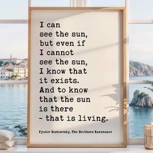 May include: A framed print with a quote by Fyodor Dostoevsky: "I can see the sun, but even if I cannot see the sun, I know that it exists. And to know that the sun is there - that is living." The print is in a light wood frame.