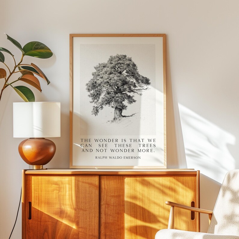 Może przedstawiać: Oprawiony czarno-biały wydruk drzewa z cytatem "THE WONDER IS THAT WE CAN SEE THESE TREES AND NOT WONDER MORE. RALPH WALDO EMERSON." Wydruk jest wyświetlany na drewnianej szafce obok lampy.