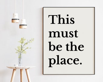 May include: A beige poster with black text that reads "This must be the place."