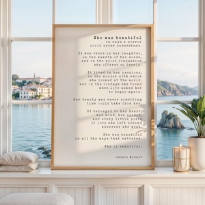 May include: A rectangular framed wall art print featuring black typewriter-style text on a cream background. The poem reads: She was beautiful in ways a mirror could never understand. It was there in her laughter, in the warmth of her words.