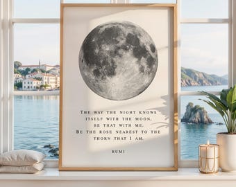 May include: A rectangular framed wall art print featuring a detailed grayscale image of the moon centered at the top. Below the moon, black text reads: The way the night knows itself with the moon, be that with me. Be the rose nearest to the thorn that I am. Rumi.
