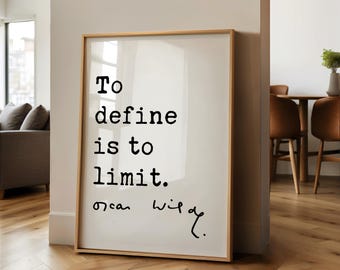 May include: A rectangular framed wall art piece featuring a light background with black text that reads, "To define is to limit." followed by the signature "Oscar Wilde" in a handwritten script style. The frame is made of light-colored wood.