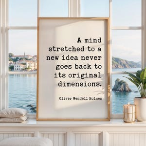 May include: A rectangular framed wall art piece featuring a white background with black typewriter-style text that reads: A mind stretched to a new idea never goes back to its original dimensions. Oliver Wendell Holmes is printed below.
