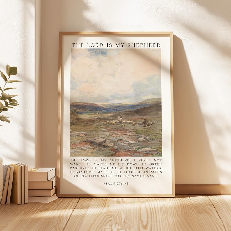 May include: Framed art print featuring a pastoral landscape with sheep and figures. The artwork has a vintage aesthetic, with a color palette of greens, blues, and beige. Text at the top reads "THE LORD IS MY SHEPHERD", with a verse below. The frame is a light wood color.