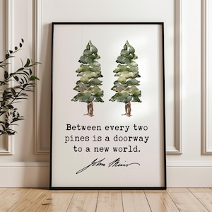 May include: A framed art print featuring two watercolor pine trees in shades of green and brown. The print includes the quote "Between every two pines is a doorway to a new world" and the signature of John Muir.