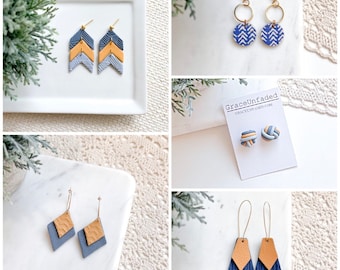 May include: Four pairs of handmade polymer clay earrings in blue and yellow. The earrings are in the shape of arrows, circles, knots, and geometric shapes.