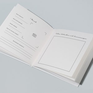 May include: Open white journal with lined pages and handwritten text in German. The journal includes prompts for recording weight, head circumference, height, and special moments. A photo icon is also present.