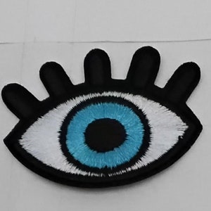 May include: A black and white embroidered eye patch with a blue eye. The eye patch is a popular symbol of protection and good luck.