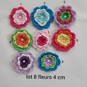 Könnte beinhalten: Eine Sammlung von acht gehäkelten Blumen-Applikationen in verschiedenen Farben, jeweils etwa 4 cm im Durchmesser. Die Blumen haben geschichtete Blütenblätter und eine zentrale Perle, mit Farben wie Rosa, Blau, Grün, Orange und Lila. Der Text auf dem Bild lautet "lot 8 fleurs 4 cm".