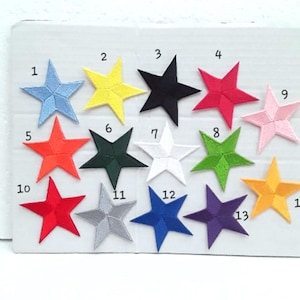Peut inclure: Un ensemble de 14 patchs thermocollants représentant des étoiles de différentes couleurs. Les étoiles sont numérotées de 1 à 14. Les couleurs incluent le bleu, le jaune, le noir, le rouge, le rose, le vert, le blanc et le violet.